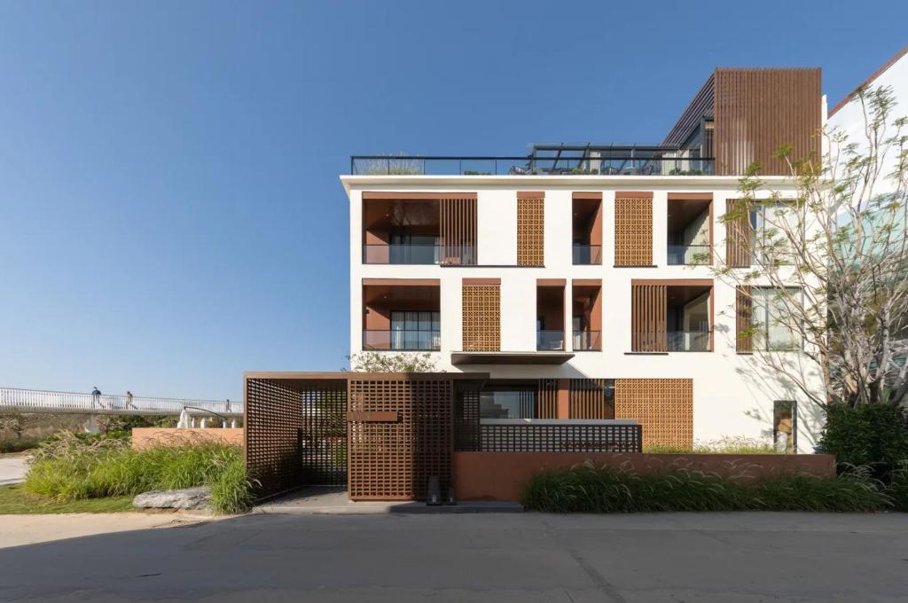 a tall white building with a fence in front of it at Guanlu Art Hotel in Huadu
