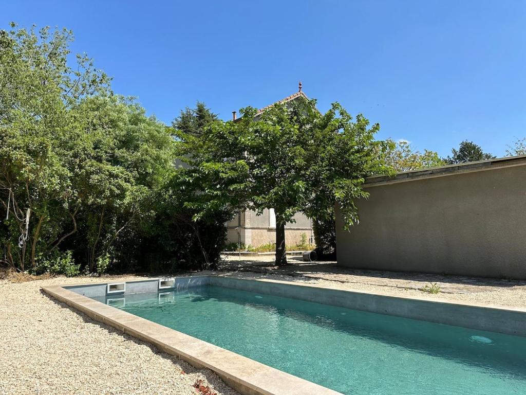 a swimming pool in a yard next to a fence at La maison d'Ulysse in Saint-Hippolyte-de-Caton