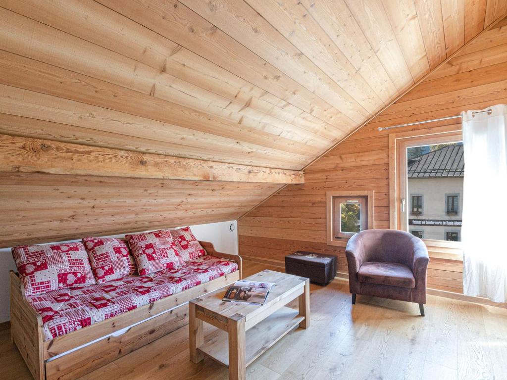 un salon avec un canapé et une chaise dans l'établissement Bel Appartement au Centre de Chamonix, à 350m des Pistes, Parking et Services Inclus - FR-1-343-200, à Chamonix-Mont-Blanc