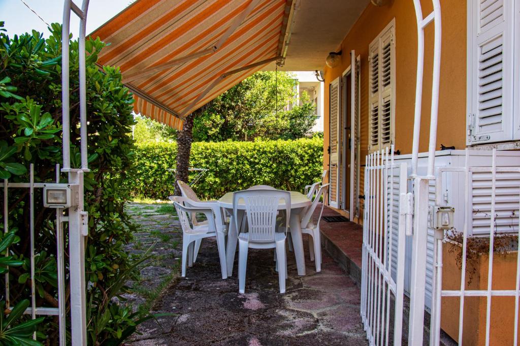 a patio with a table and chairs under an umbrella at La Casa di Sara in Marcelli