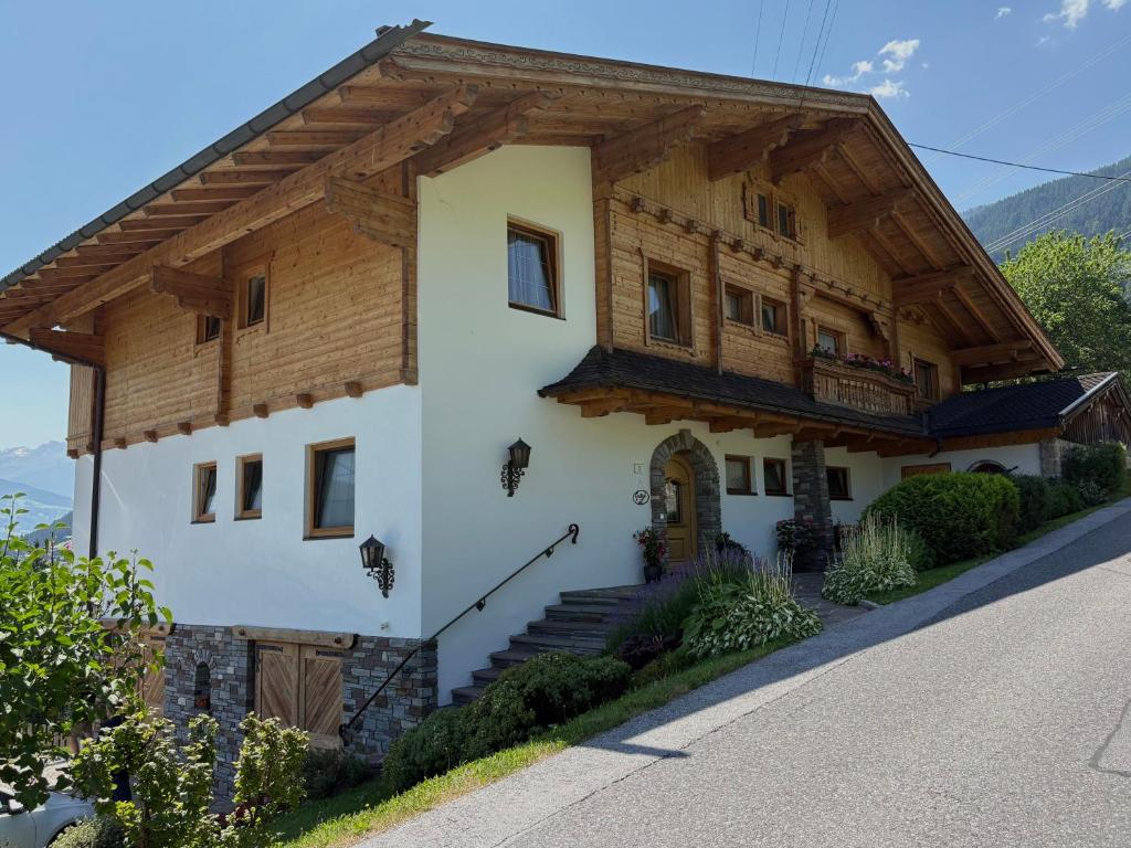 a house with a wooden roof on a street at Fankhauser Apartments - am Berg in Ried im Zillertal