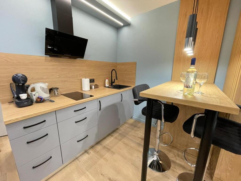 cocina con armarios blancos y encimera con mesa en Sea Supreme Studio, en Balchik