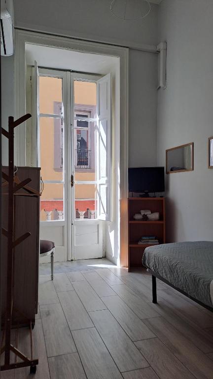 a bedroom with a bed and a door with a window at Cupola San Marcellino in Naples