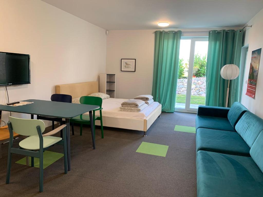 a living room with a bed and a table and a couch at Albatrosa 17 - apartament nr 2 in Rewal