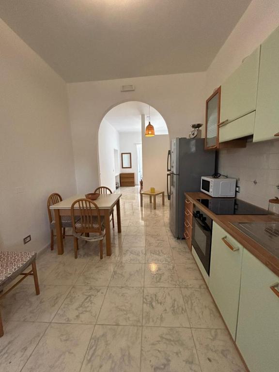 a kitchen with a table and a dining room at Green Appartament in Marina di Camerota