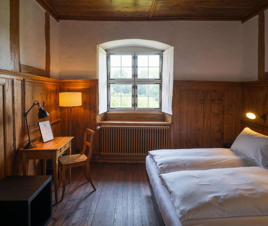 una camera da letto con due letti, una scrivania e una finestra di Klosterherberge Solothurn Self Check-in a Solothurn