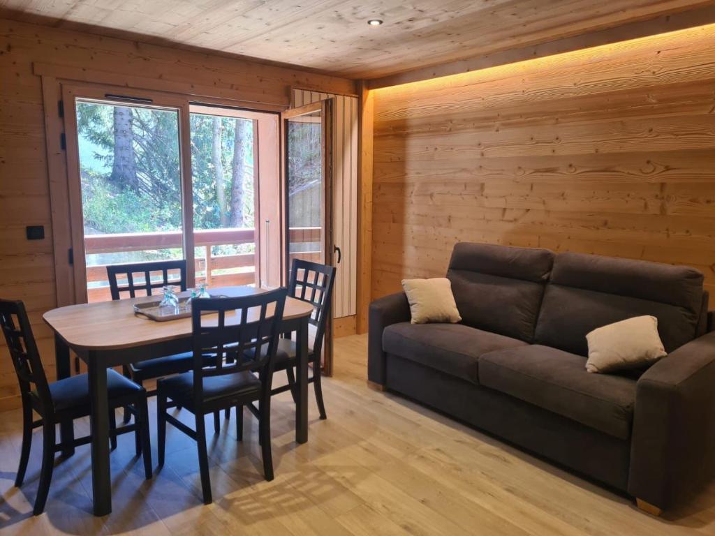 a living room with a couch and a table and chairs at Ma P'tite Étoile in Le Grand-Bornand
