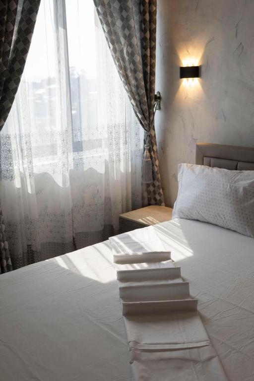 una camera da letto con un letto bianco con una finestra di Akwuaba a Brazzaville