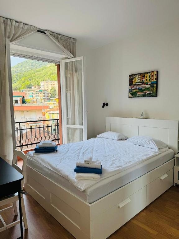 a bedroom with a large white bed with a window at Elegant Apartments Rapallo in Rapallo