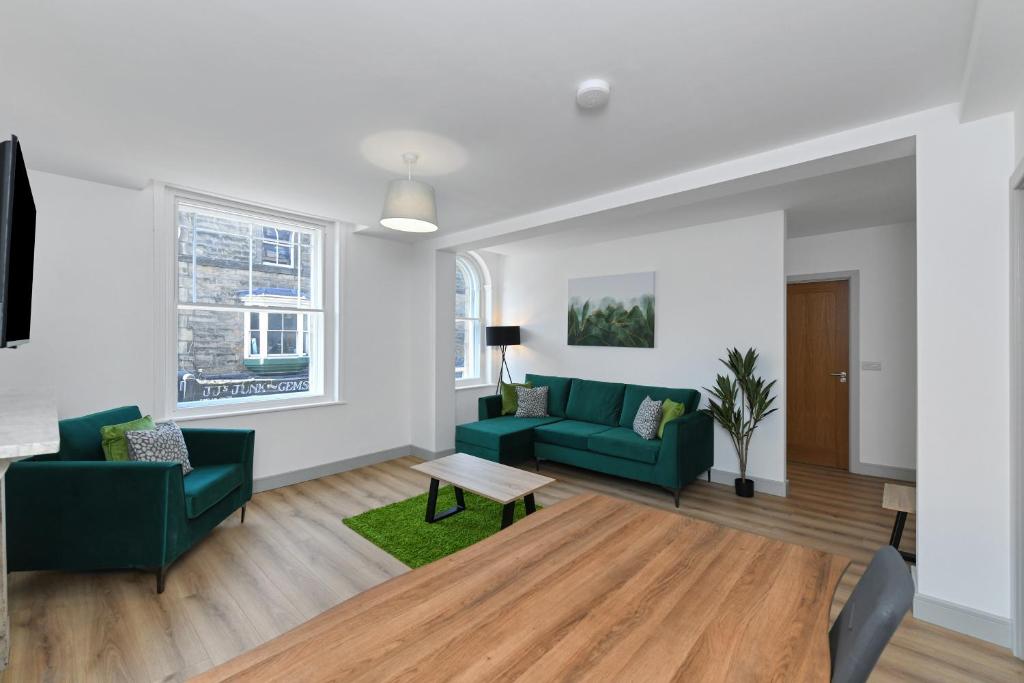 una sala de estar con 2 sofás verdes y una mesa. en Convenient 1 - Bed in Central Matlock Near Station, en Matlock