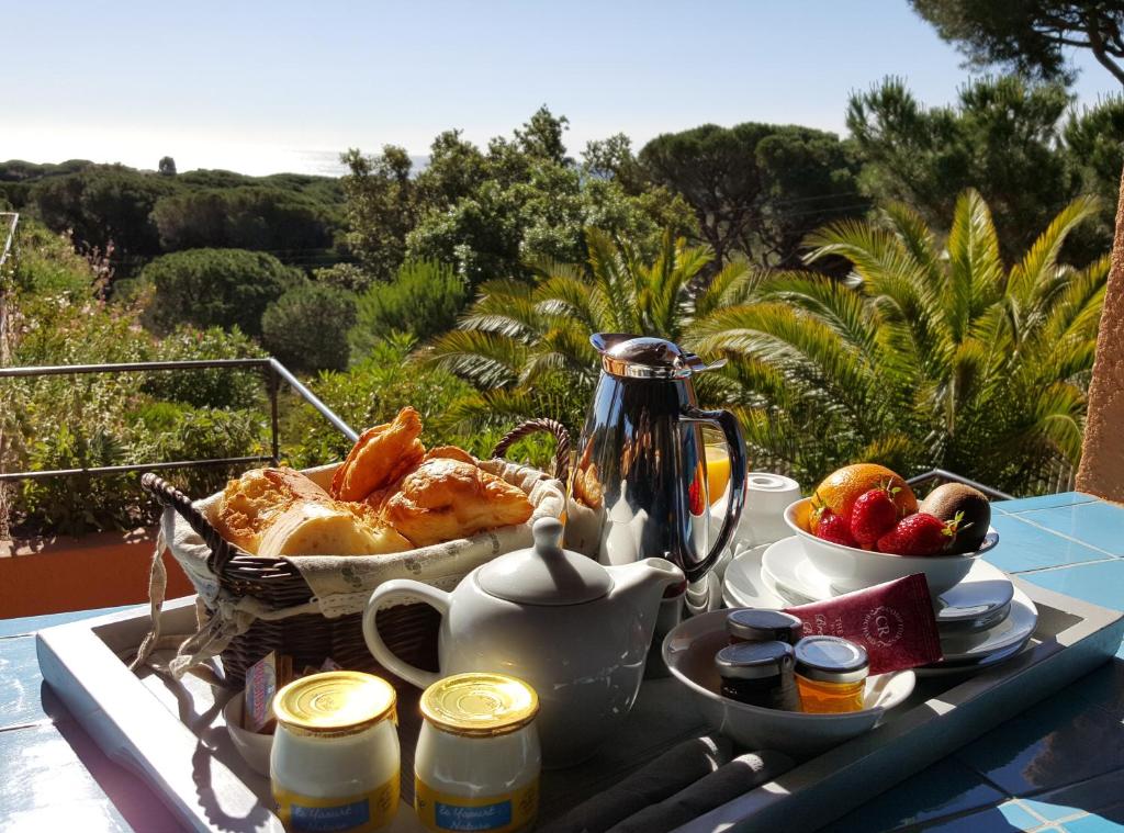 a table with a tray of breakfast food on a balcony at Hôtel les Bouis - Vue mer in Saint-Tropez