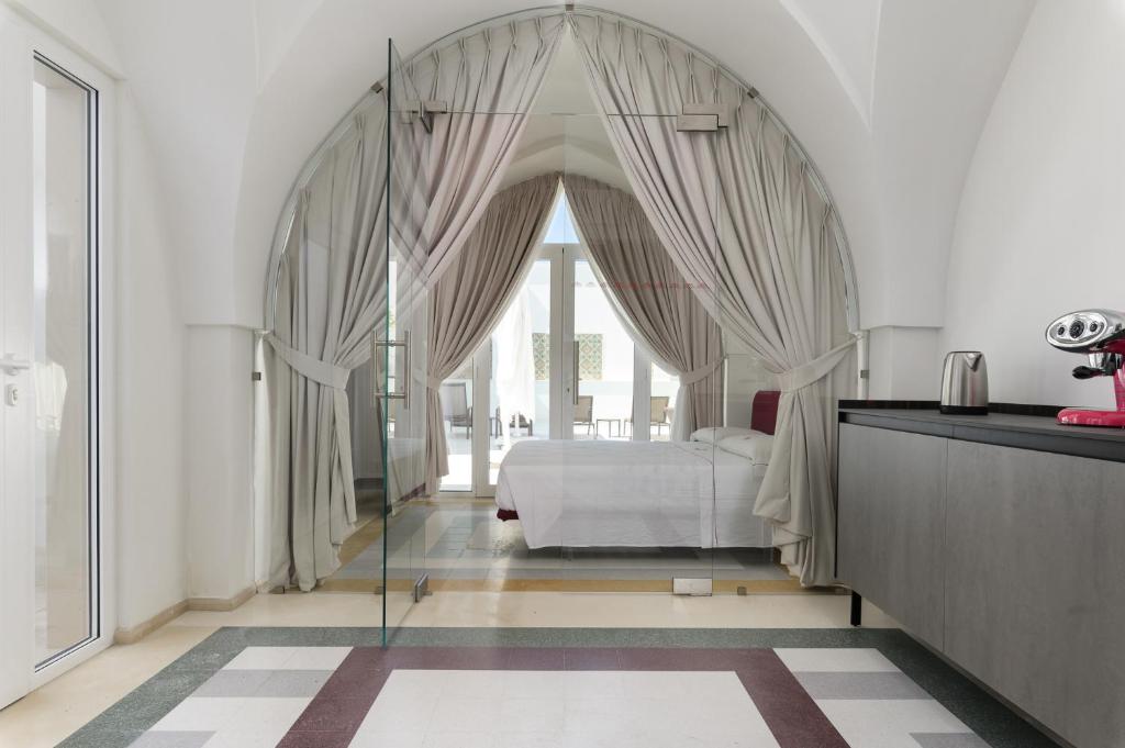 a bedroom with a bed and a large window at Hydeout Palace - Luxury & Spa Suites by Wonderful Italy in San Vito dei Normanni