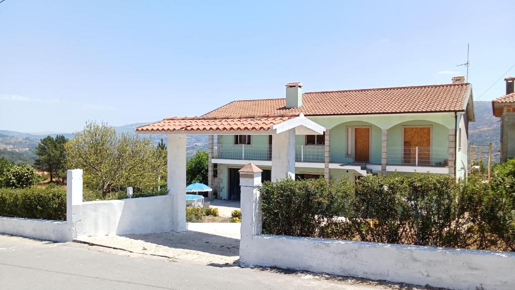 a blue house with a red roof at Private Pool River View Villa in Baião