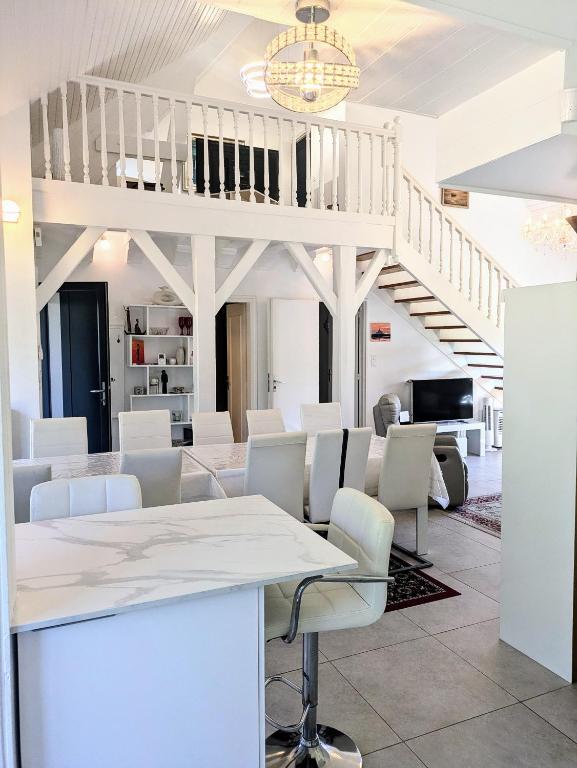 une chambre blanche avec des chaises blanches et un escalier dans l'établissement Maison moderne 8 personnes, jardin, parkings, fibre THD, plage 5 min, à Vannes