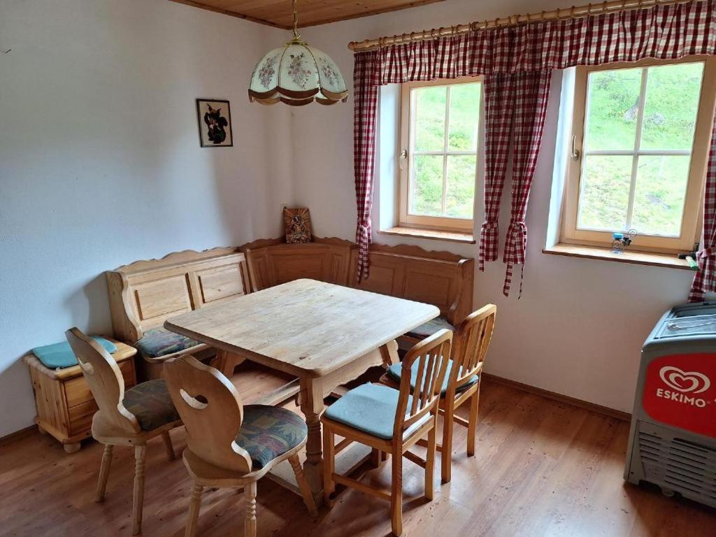 Un comedor con mesa y sillas de madera. en TauernBergAlm, en Winkl Heiligenblut