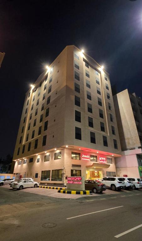 a large building with cars parked in a parking lot at شقق جوين للوحدات السكنية المفروشة- اقتصادي in Jeddah