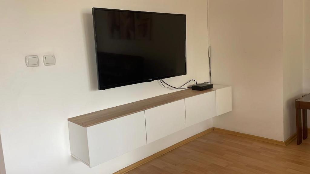 a flat screen tv hanging on a white wall at BT Lux apartment 2 in Skopje