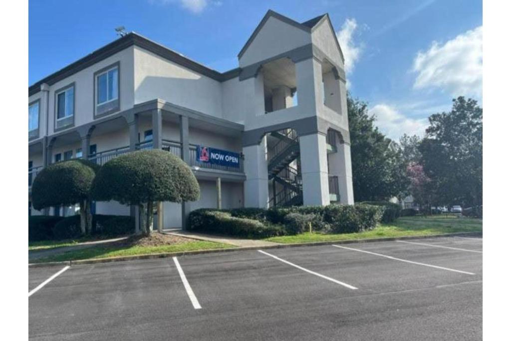 a building with a parking lot in front of it at Studio 6 Suites Norcross, GA in Norcross