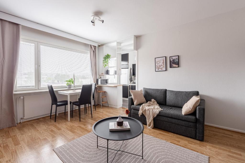 a living room with a couch and a table at Comfy Downtown Studio at Prime Location in Jyväskylä