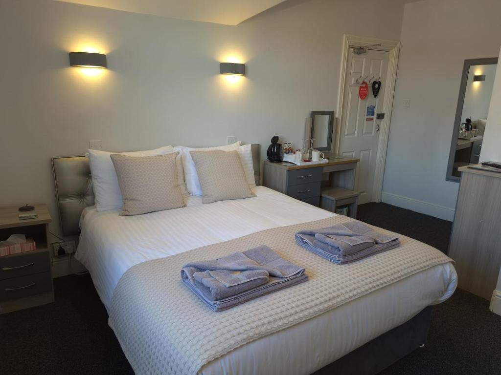 a bedroom with a bed with two towels on it at Barclay Guest House in Paignton