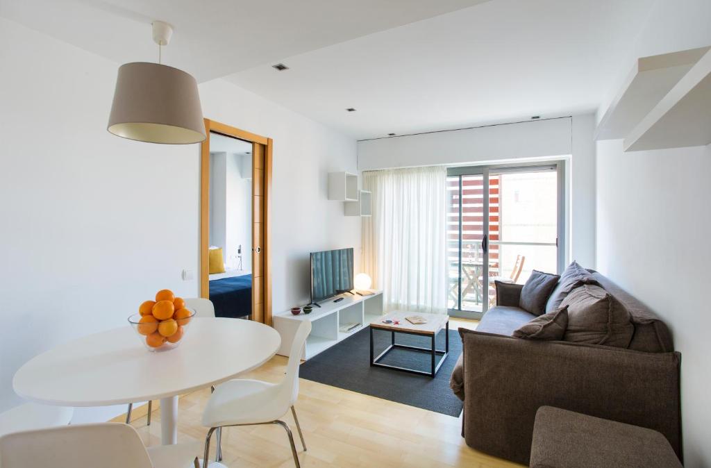a living room with a table and a couch at Durlet Rambla Mar Apartments in Barcelona