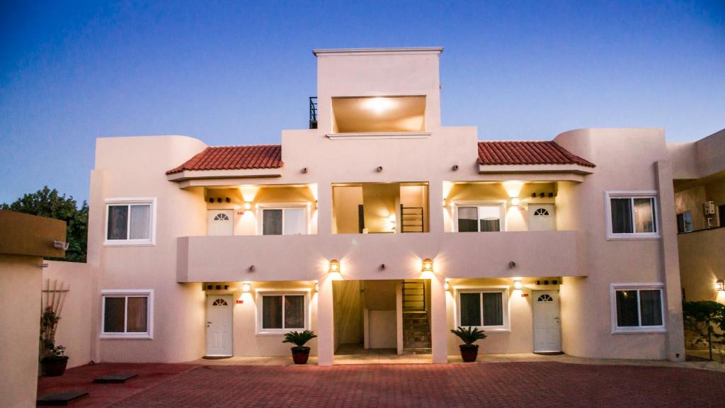 a white house with a red roof at Bugambilias Suites in Loreto