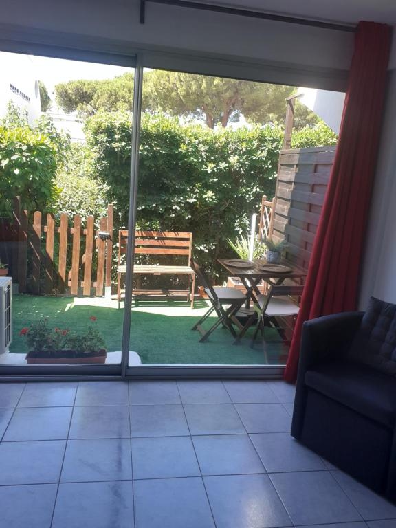 Cette chambre offre une vue sur une terrasse dotée d'une table et d'un banc. dans l'établissement Charmant studio au Ponant, à La Grande Motte