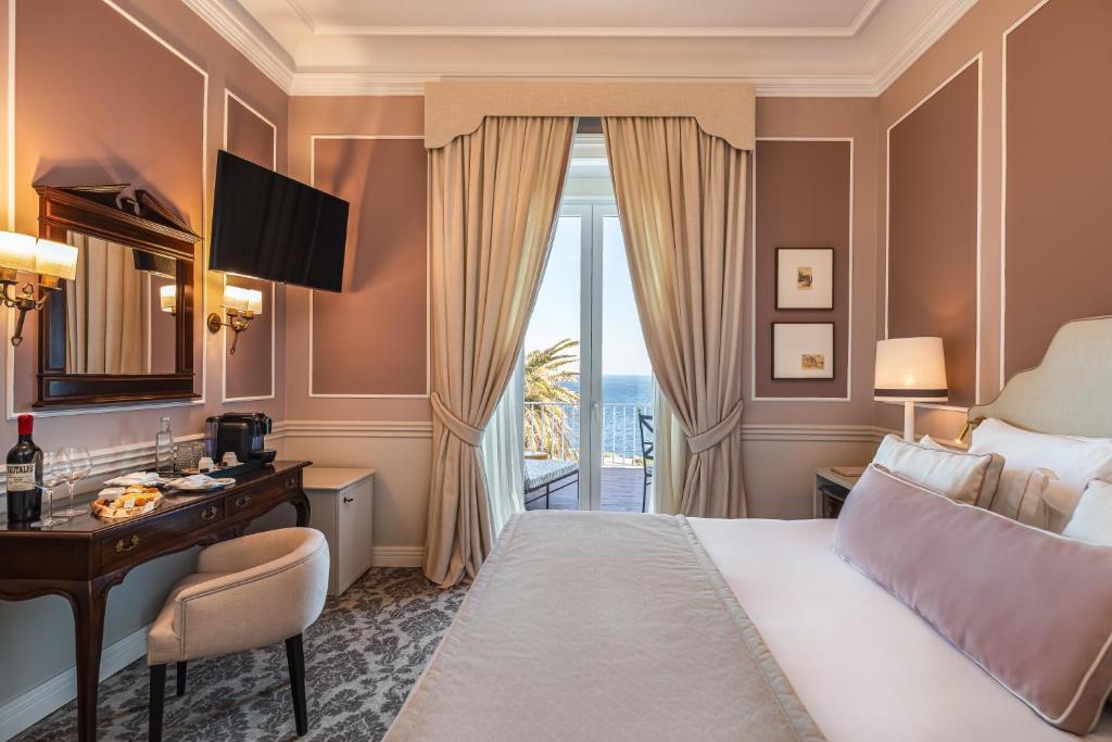Una habitación de hotel con una cama, un escritorio y una ventana. en Longevity Senses - Cascais Boutique Hotel - Adults Only, en Cascais