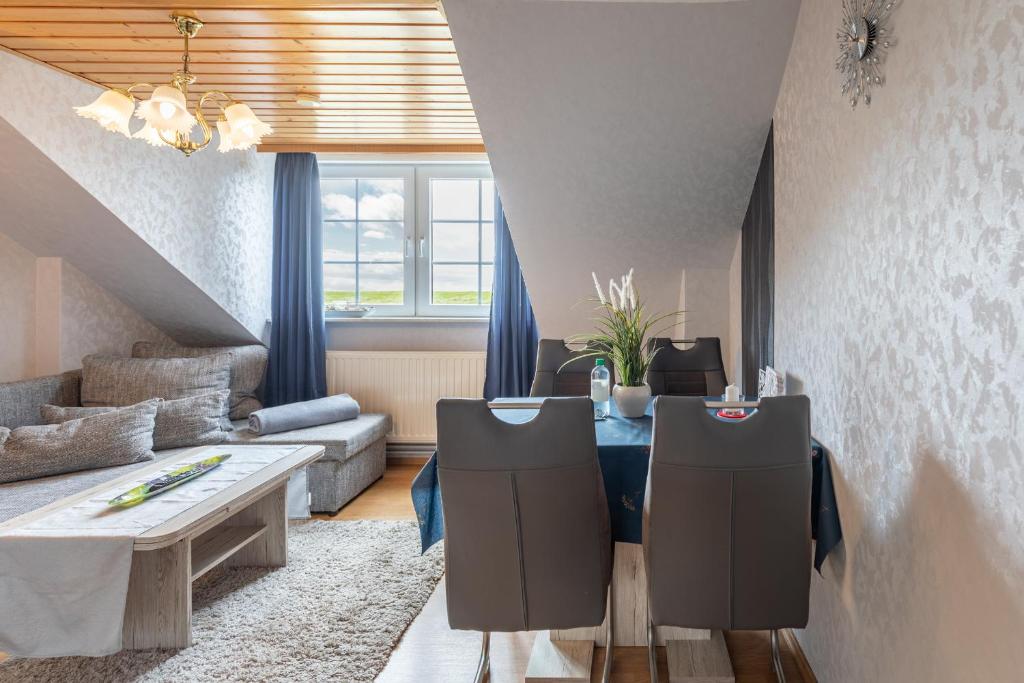 a living room with a table and a couch at Haus Seeblick _ Wohnung 1 in Dagebüll