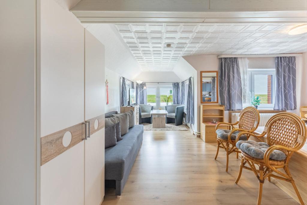 una sala de estar con un sofá y sillas en Haus Seeblick _ Wohnung 2, en Dagebüll