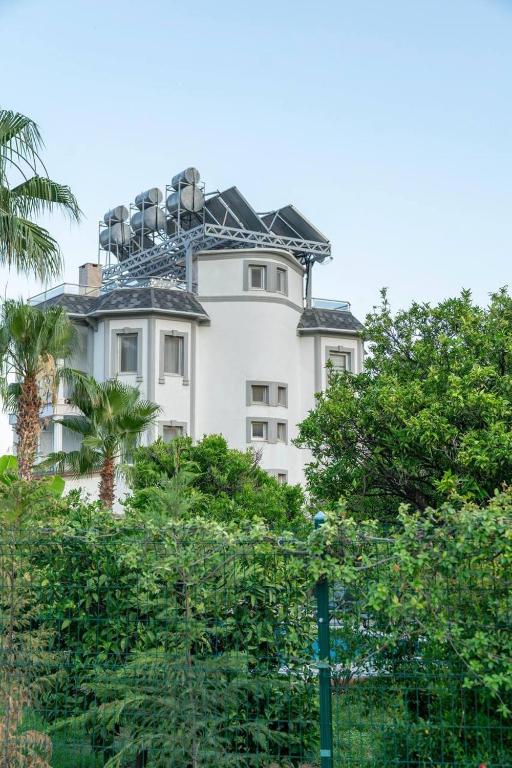 a white building with trees in front of it at Green Garden Otel in Kemer