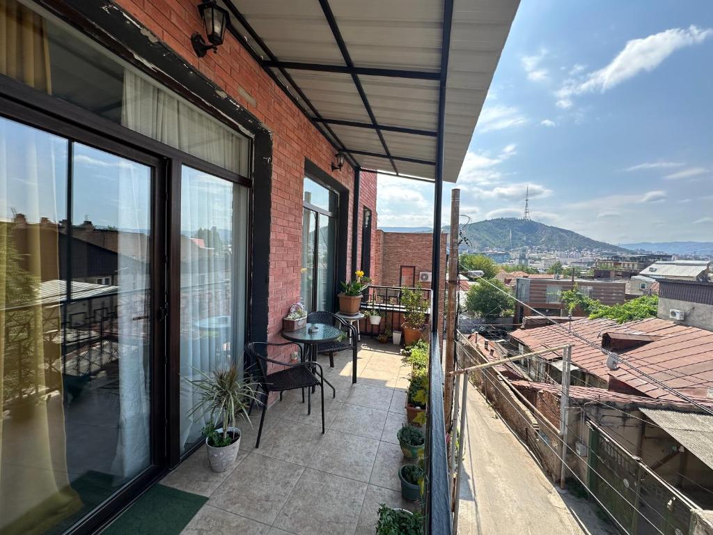 een balkon met een tafel en stoelen op een gebouw bij A p a r t m e n t AnnaMari O l d T b i l i s i in Tbilisi City