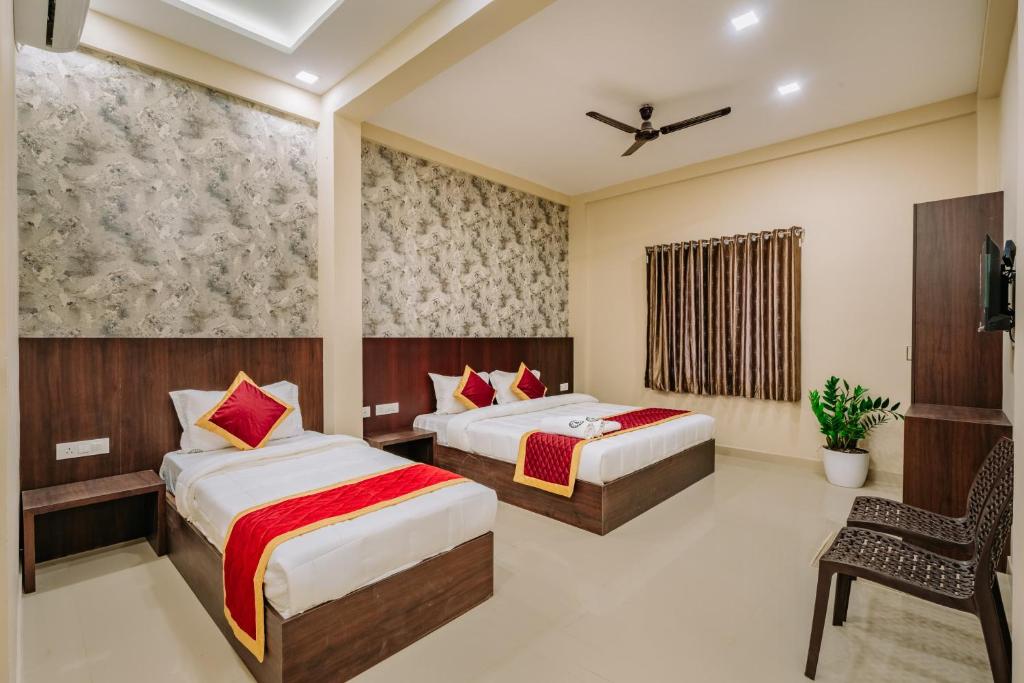 a hotel room with two beds and a chair at Boat Residency in Cochin