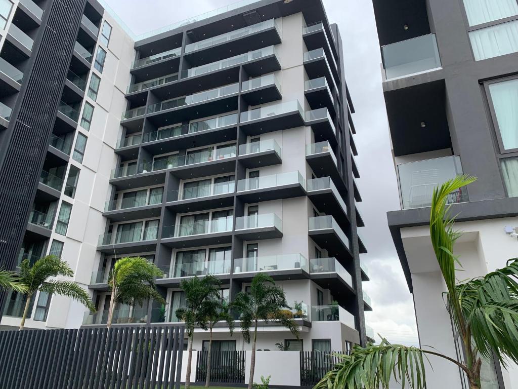 an apartment building with palm trees in front of it at Nova luxe 2 Bed Executive Stay in Accra