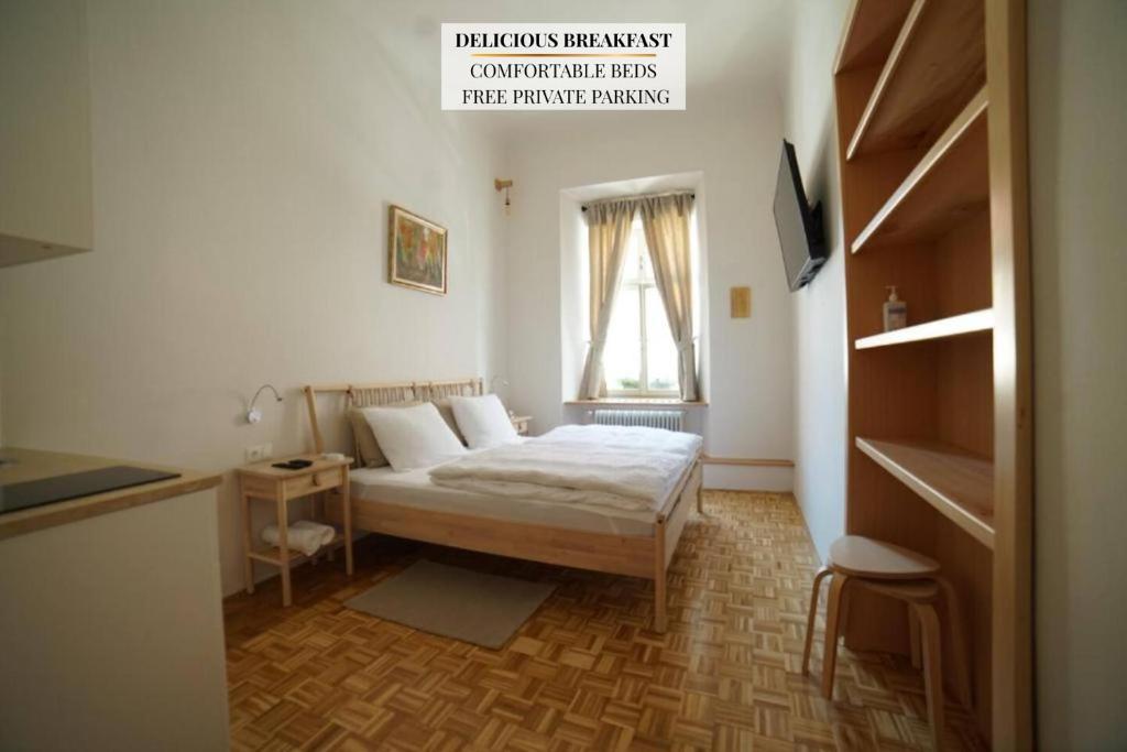 a bedroom with a bed and a table and a window at Sobe Proštija in Ptuj