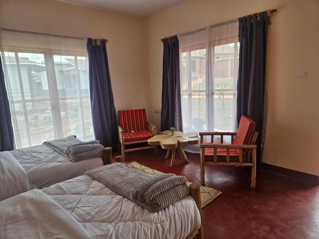 カラトゥにあるAfrican Royal Villa and Campsiteのベッド2台とテーブルと椅子のある寝室