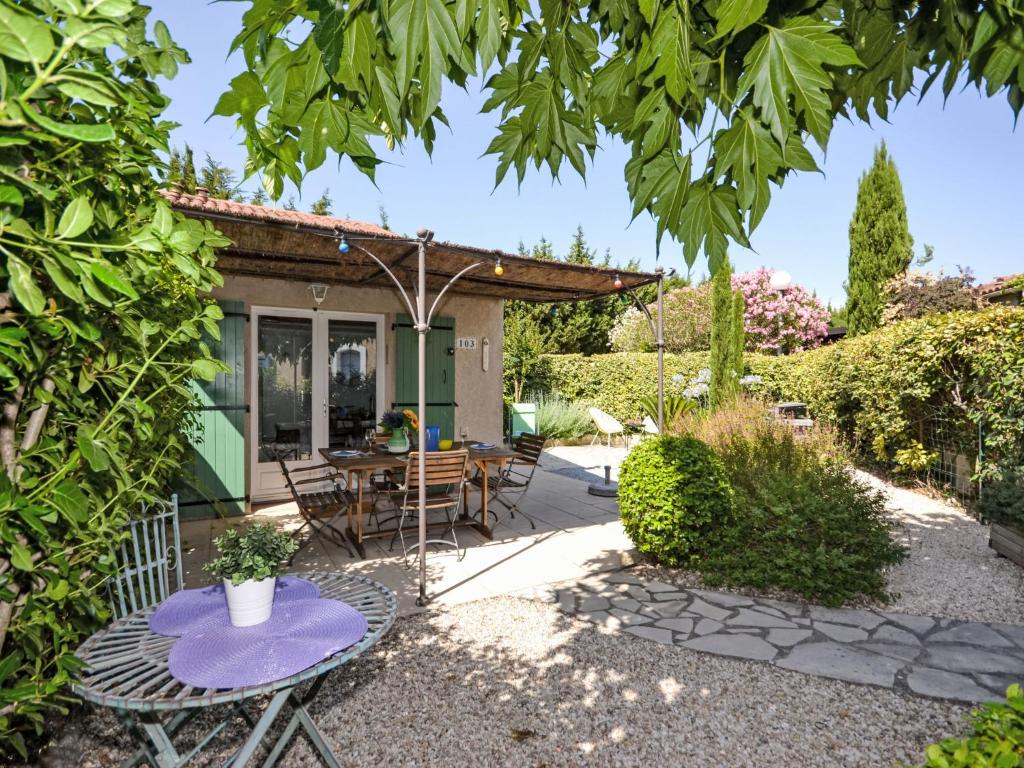 un patio avec une table et des chaises devant une maison dans l'établissement Holiday Home Val d'Alpilles by Interhome, à Maussane-les-Alpilles