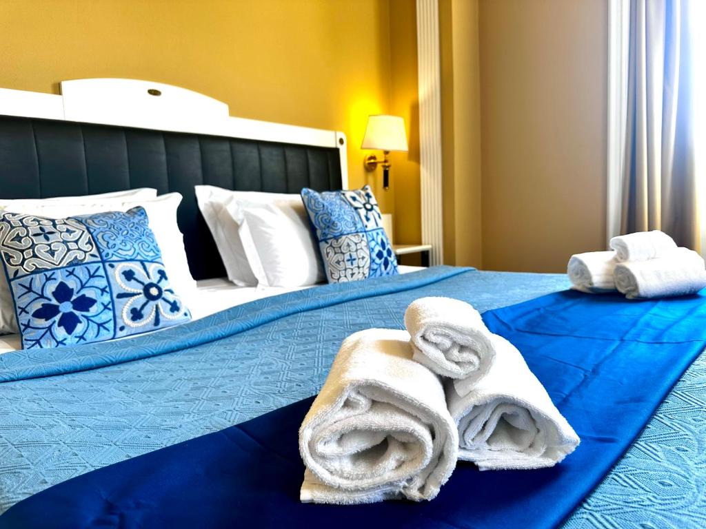 a bedroom with two beds with towels on them at Greif Hotel Maria Theresia in Trieste