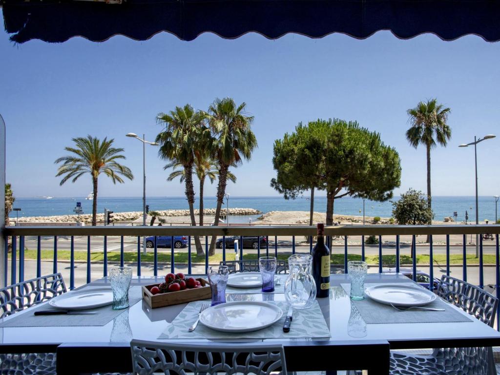 - une table avec une bouteille de vin et une vue sur la plage dans l'établissement Apartment le grand large-1 by Interhome, à Cagnes-sur-Mer