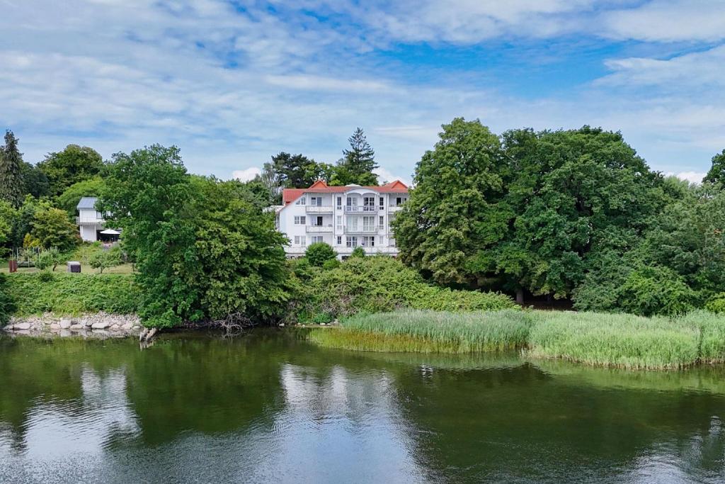 ラウターバッハにあるVilla Vilmblick FeWo 15 - Meerblick, Balkonの川の横の丘の上の大きな白い家