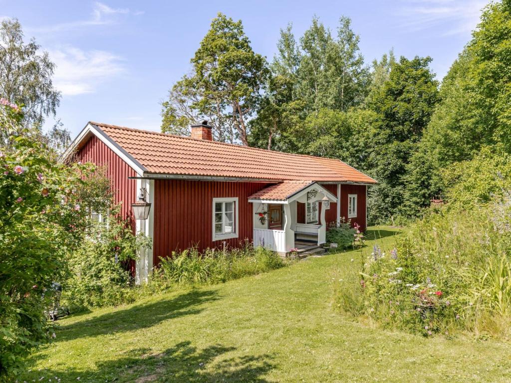 a red cottage in the middle of a yard at Holiday Home Sjödrömmen by Interhome in Näsviken