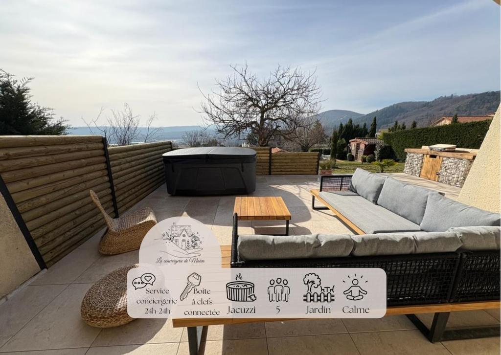 a patio with a couch and a table with signs on it at La casa bella vista in Enval