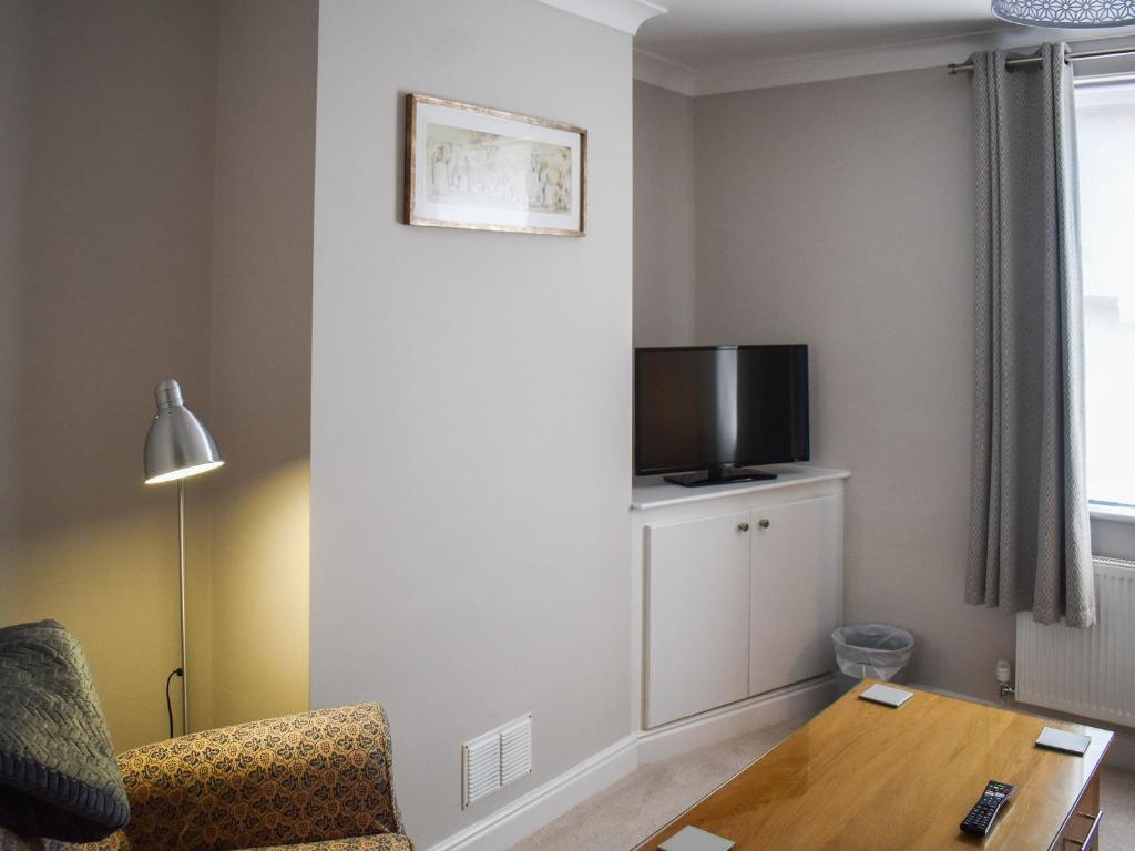 a living room with a tv and a table at No 12 Cottage in Mold