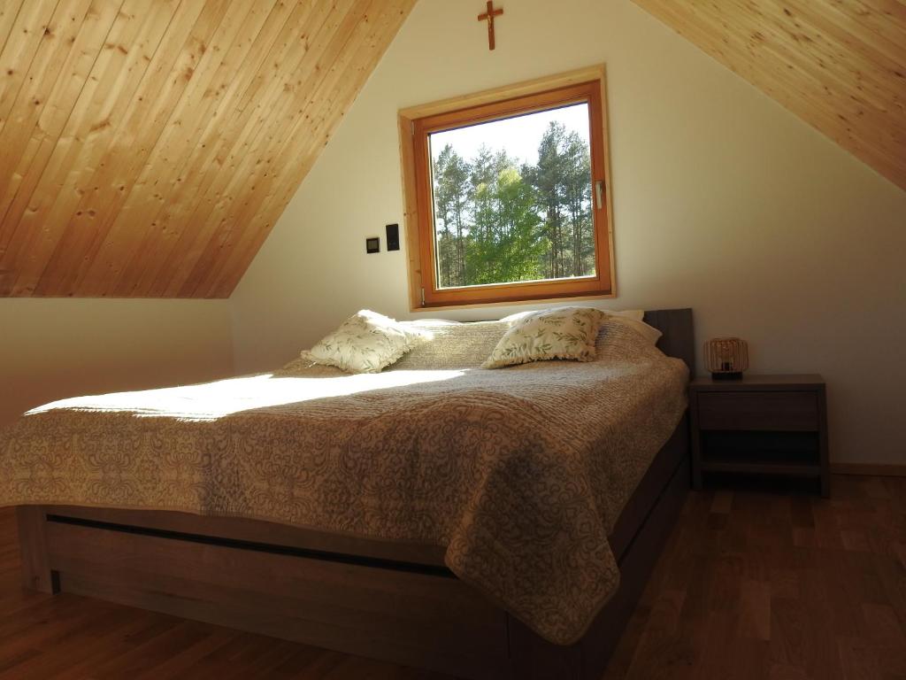 a bedroom with a bed with a window at Dolina nad Drawa 