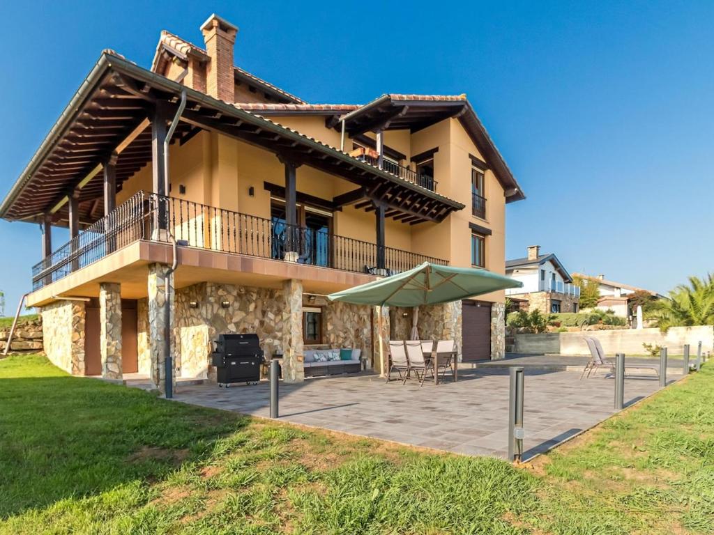 OngayoにあるMagnifica casa con vistas espectacularesのパティオと傘が備わる大きな家