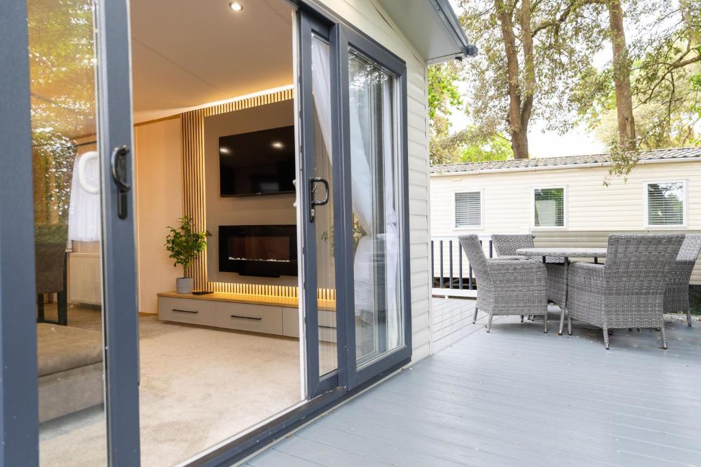 a sliding glass door leading to a patio with a table at Chantry Lodge in Christchurch