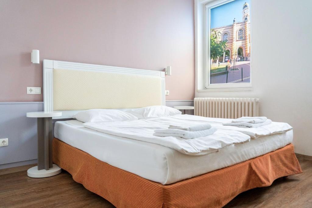 A bed or beds in a room at Hotel Metro