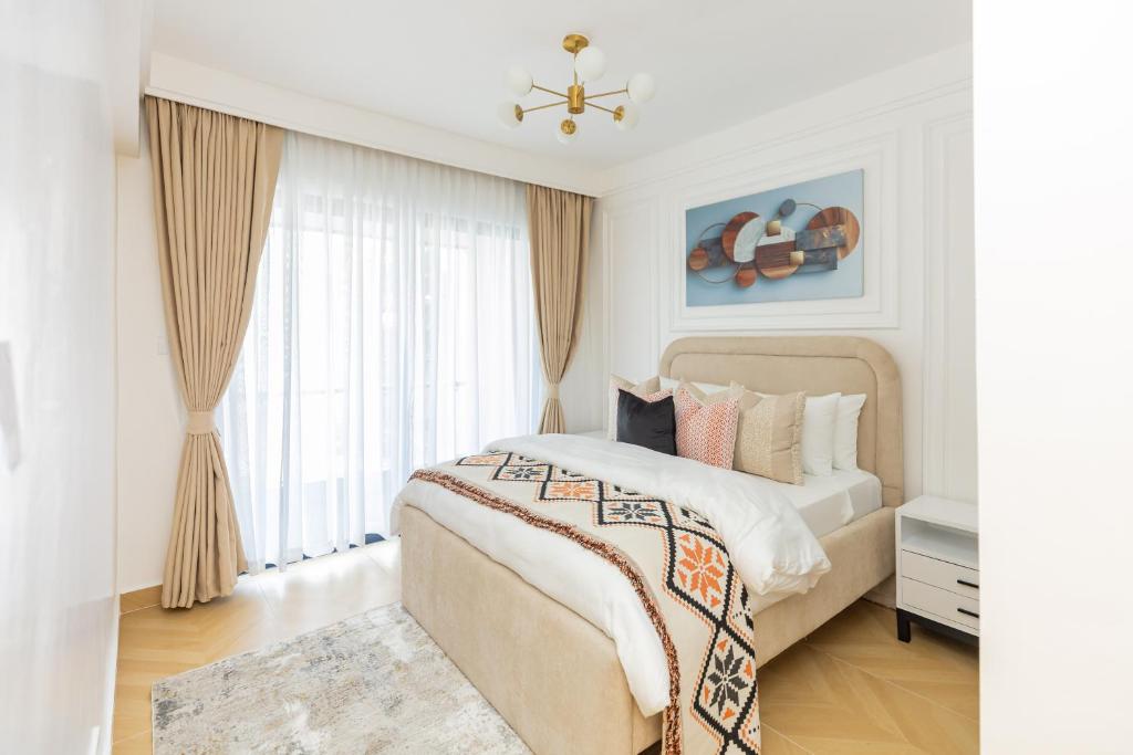 a white bedroom with a large bed and a window at TheEJResidence- 2Bedroom All Ensuite- 7km from JKIA 3km from SGR and Expressway along Mombasa Road-Nairobi Kenya in Nairobi