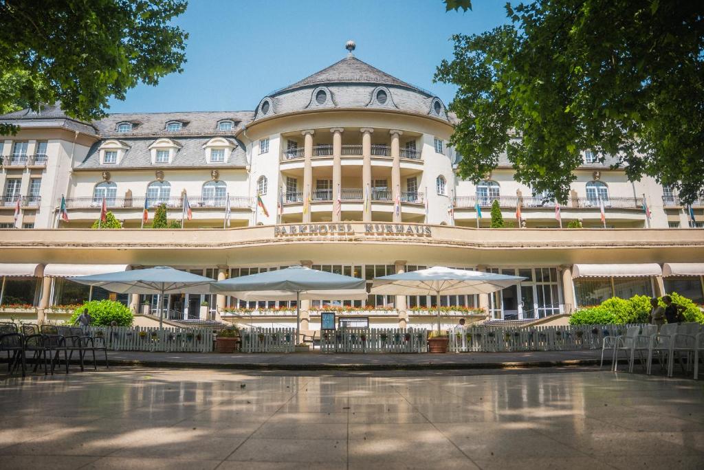 a large building with umbrellas in front of it at Parkhotel Kurhaus in Bad Kreuznach