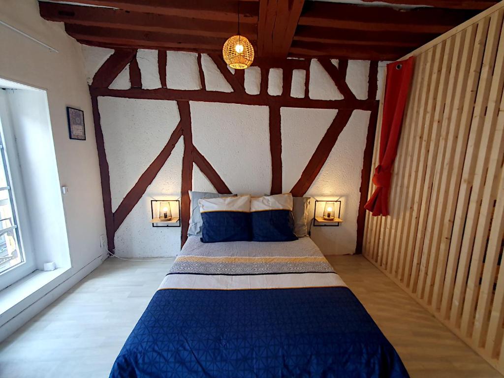 a bedroom with a blue bed in a room at La Trame Bourguignonne - Centre ville in Auxerre